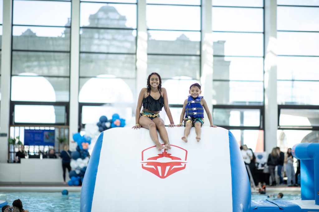 Kids at the top of an inflatable slide during The Plunge's kids summer camp in Mission Beach, San Diego